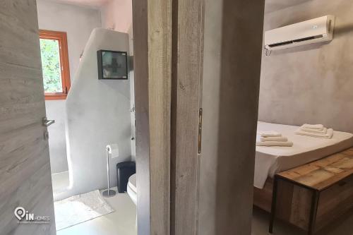 a small room with a bed and a small bathroom at Mani Tu With Breathtaking View 2 in Éxo Nímfion
