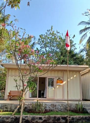 a small house with a flag in front of it at Tiny Container Cabin @ Umah Chronosophere - Bali in Balian