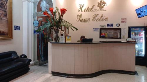 a restaurant with a counter with a vase of flowers at hotel paseo colon inn in Barranquilla