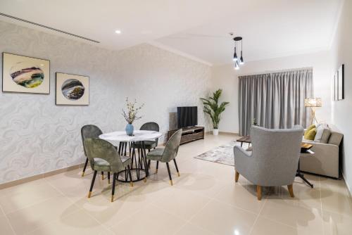 a living room with a dining room table and chairs at SIMPLY COMFORT in Sarai Palm Jumeirah in Dubai
