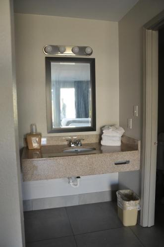 y baño con lavabo y espejo. en My Home & Suites Covington en Covington