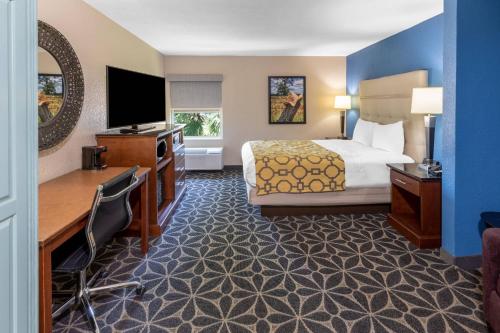 a hotel room with a bed and a flat screen tv at Baymont by Wyndham McAllen Pharr in McAllen