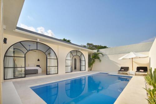 a villa with a swimming pool and a bedroom at The Grand Daha Luxury Villas in Seminyak