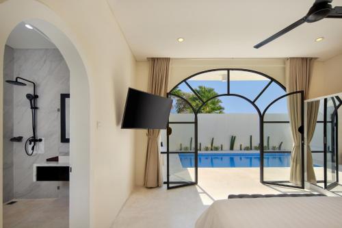 a bedroom with a view of a swimming pool seen through a window at The Grand Daha Luxury Villas in Seminyak