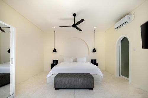 a bedroom with a bed and a ceiling fan at The Grand Daha Luxury Villas in Seminyak