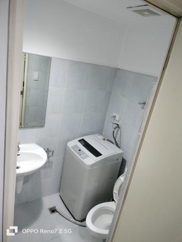 een witte badkamer met een toilet en een wastafel bij Glenda Place Aurum at Sea residences in Manilla