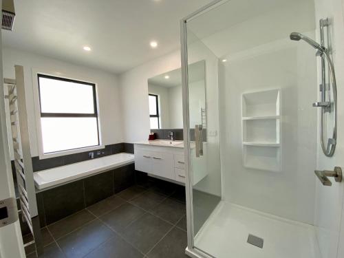 a bathroom with a glass shower and a sink at Style, Functional with Space in Twizel