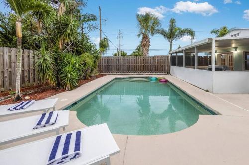 a swimming pool in the backyard of a house at Serenity Retreat Pool BBQ Swing Set WiFi+ in West Palm Beach