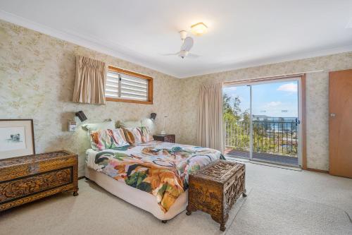 a bedroom with a bed and a large window at Yurung, 26 Dulconghi Street in Crescent Head