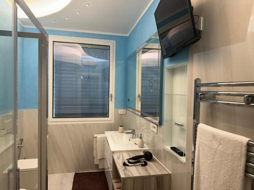 a bathroom with a sink and a tv on the wall at Ranco Villa Lina in Ranco
