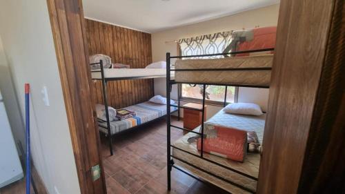 a room with three bunk beds in a house at Cabaña en Olmue con piscina compartida in Granizo