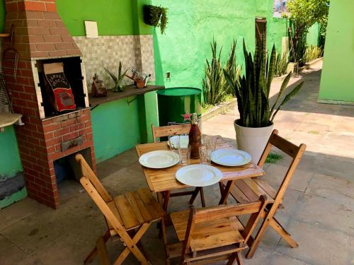 勞魯－迪弗雷塔斯的住宿－“Mar doce Lar”，一张木桌、两把椅子和一张桌子及盘子