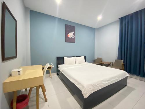 a bedroom with a bed and a table and a desk at An Nhiên Hotel in Tây Ninh