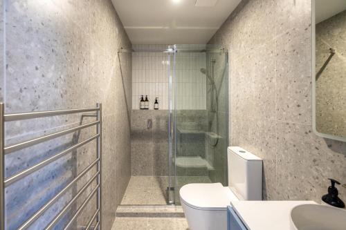 a bathroom with a shower and a toilet and a sink at Onetangi Beach Stays Studio 2 - Coast & Country in Onetangi