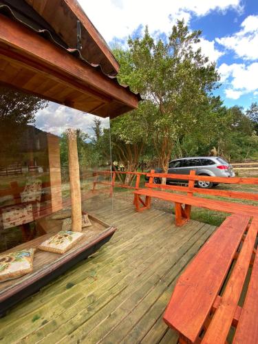 une terrasse en bois avec un banc et une voiture dans l'établissement CABAÑAS RUCA MALAL, à Futrono