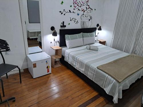 a bedroom with a large bed and a chair at Sobrado Botafogo in Rio de Janeiro