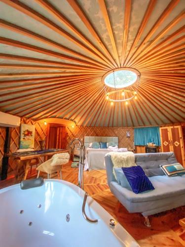 a room with a tub and a couch and a bed at Glamping montain experience in São Joaquim