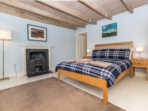 a bedroom with a bed and a fireplace at Wdig Farmhouse - Qc1263 in St. Davids