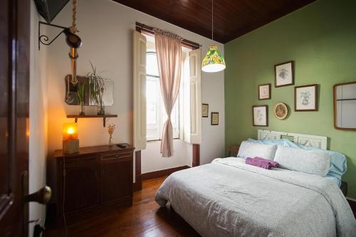 - une chambre verte avec un lit et une fenêtre dans l'établissement Oliva Guesthouse, à Vila Franca de Xira
