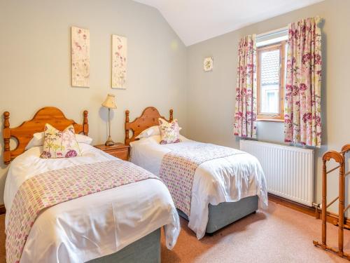 a bedroom with two beds and a window at Oak Cottage - Uk45576 in Maltby le Marsh