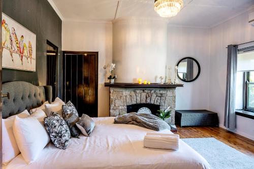 a bedroom with a large bed and a fireplace at Fairleys of Corowa in Corowa