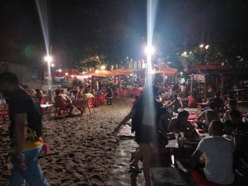 a crowd of people sitting on a beach at night at San Juan La Union Apartments in San Juan