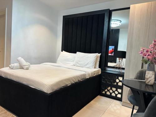 a bed with a black headboard in a room at Havens Apartment in Accra