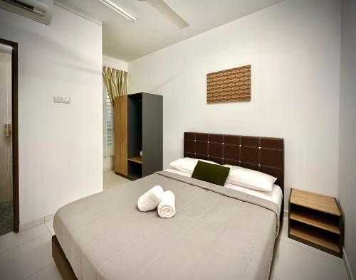 a bedroom with a large bed with two towels on it at Nureenas Residence Condominium in Ayer Keroh