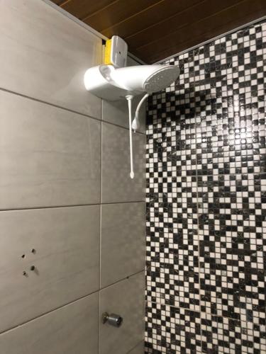 W łazience znajduje się prysznic i wentylator sufitowy. w obiekcie Tchê Hostel w mieście Porto Seguro