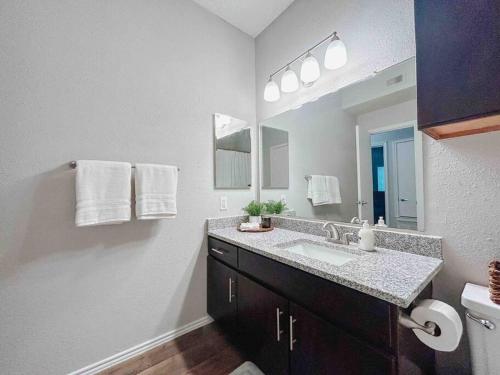 baño con lavabo y espejo grande en Warm 2-Bedroom Amongst Shaded Oaks, en Corpus Christi