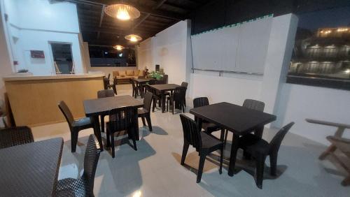 ein Restaurant mit Tischen und Stühlen und eine Küche in der Unterkunft MANIPON TRANSIENT HOUSE in San Juan