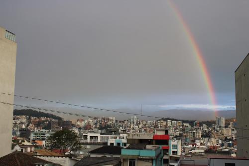 a rainbow in the sky over a city at Casa de Tulia in Quito