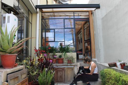 a woman sitting in front of a door with a dog at Casa de Tulia in Quito