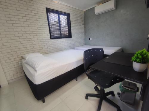 a bedroom with a bed and a desk and a table at Praia do Bessa, Caribessa - Quarto Privativo - Conforto, Paz e Sossego, excelente para descansar, trabalhar ou estudar in João Pessoa