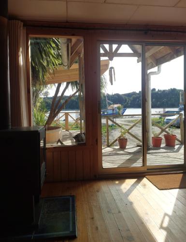 an open door to a patio with potted plants at Peumayen in Quellón