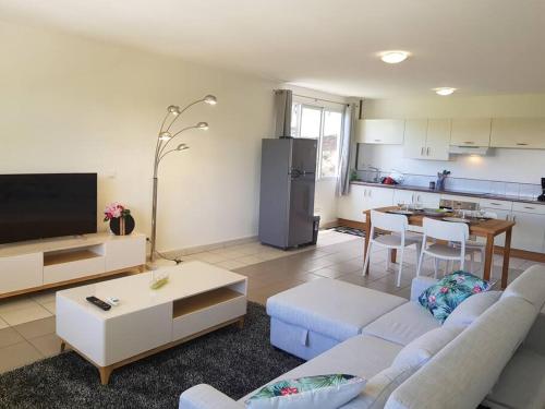 a living room with a couch and a kitchen at PAPEETE - Kahaia Apartment in Papeete