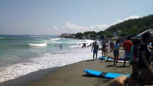a group of people on a beach with surfboards at MANIPON TRANSIENT HOUSE in San Juan