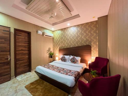 une chambre d'hôtel avec un lit et un fauteuil rouge dans l'établissement The Starlet Prime, A Hidden Peaceful Stay, à Chandigarh