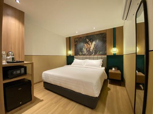 a bedroom with a bed and a painting on the wall at Alltrue Hotel Tanjungpinang Bintan in Tanjung Pinang 