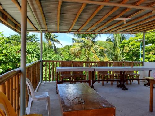 una terraza con mesa, sillas y árboles en Mandurah's Inn, Malapascua en Malapascua Island