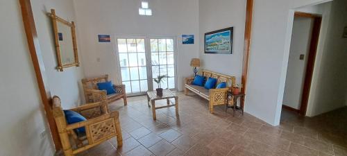 una sala de estar con almohadas y sillas azules en Casa de Playa Las Fragatas de Punta Mero, en Canoas de Punta Sal