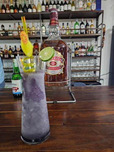 a bottle of alcohol and a drink on a table at Tulip Hotel in Louang Namtha