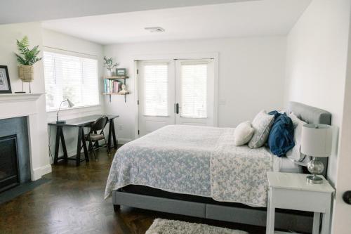 een slaapkamer met een bed, een tafel en een open haard bij The Goodville Suite in East Earl