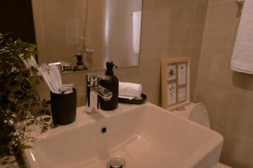 a bathroom with a white sink and a mirror at Uptown Parksuites 1BR with Wi-Fi, Free Netflix, Washer & Pool View in Manila