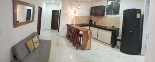 uma cozinha com um frigorífico e um sofá num quarto em zara's apartamento en coveñas em Coveñas