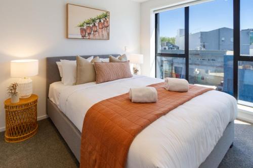 a bedroom with a large bed and a large window at Central Sunny Perch 2 bed 1 bath in Christchurch