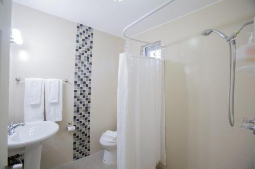 a bathroom with a shower and a toilet and a sink at Ocean Villa Guam in Tamuning