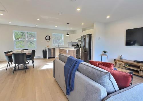 a living room with a couch and a kitchen with a table at Le domaine du Sous-Bois in Mont-Blanc