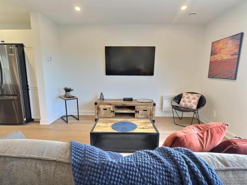 a living room with a couch and a tv at Le domaine du Sous-Bois in Mont-Blanc