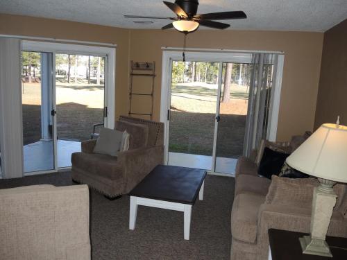 sala de estar con sofá, sillas y ventilador de techo en Lake View Golf Resort Villa 1301, en Calabash